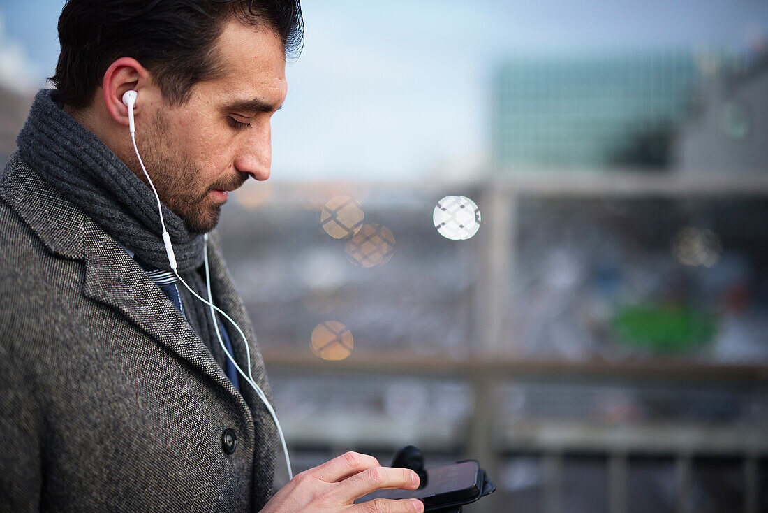 Businessman using phone outdoors in city