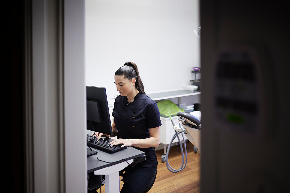 Female dentist using computer in office