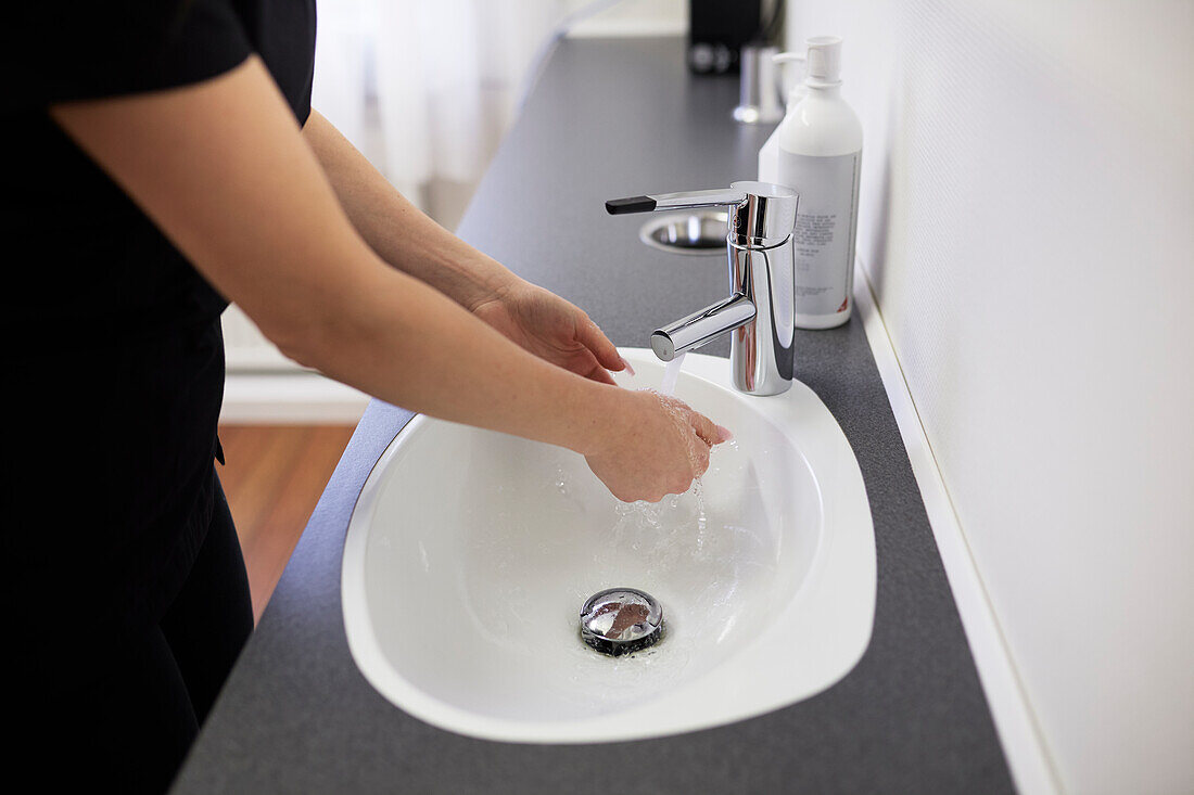 Mittelteil einer Frau beim Händewaschen