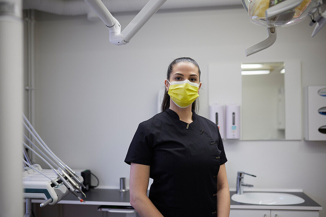 Female dentist standing in office