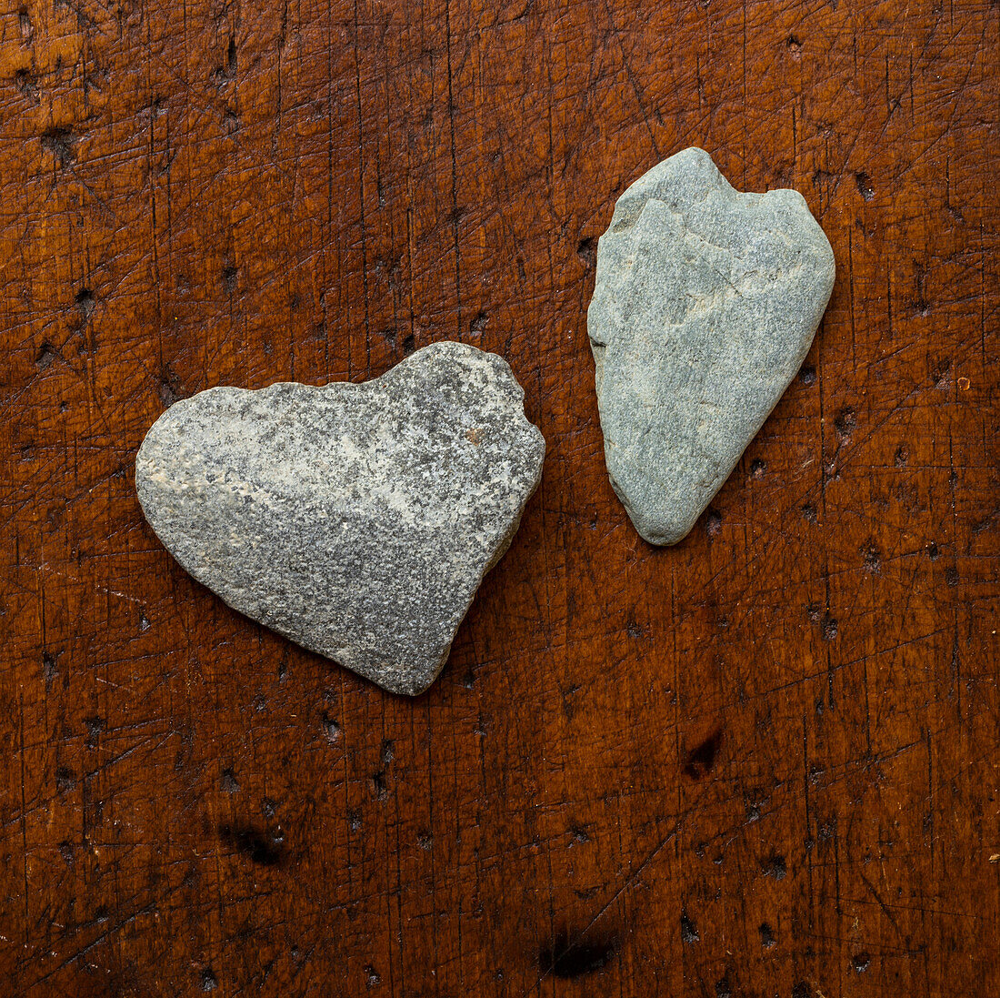 Heart shaped stones on wooden surface