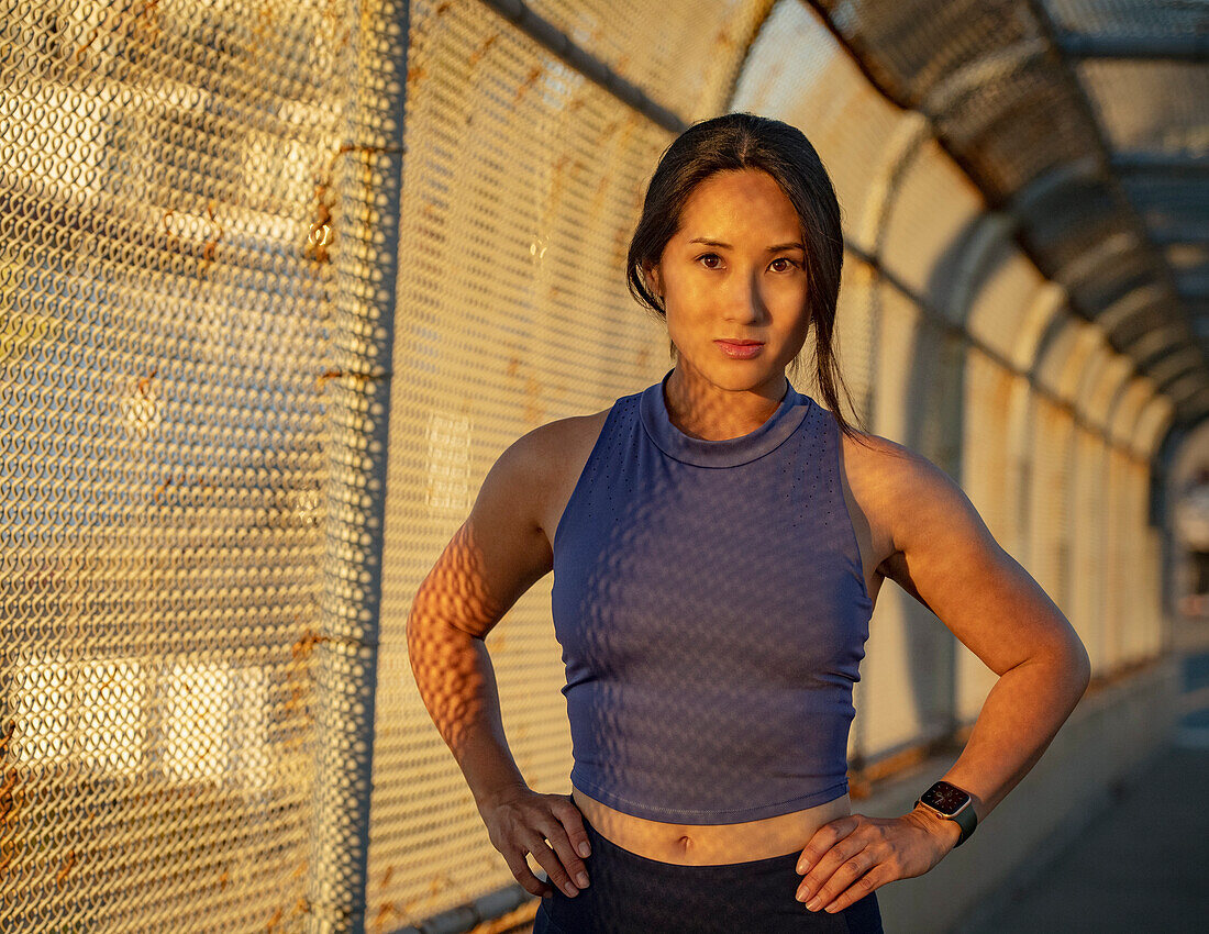 Portrait of athlete woman at fence