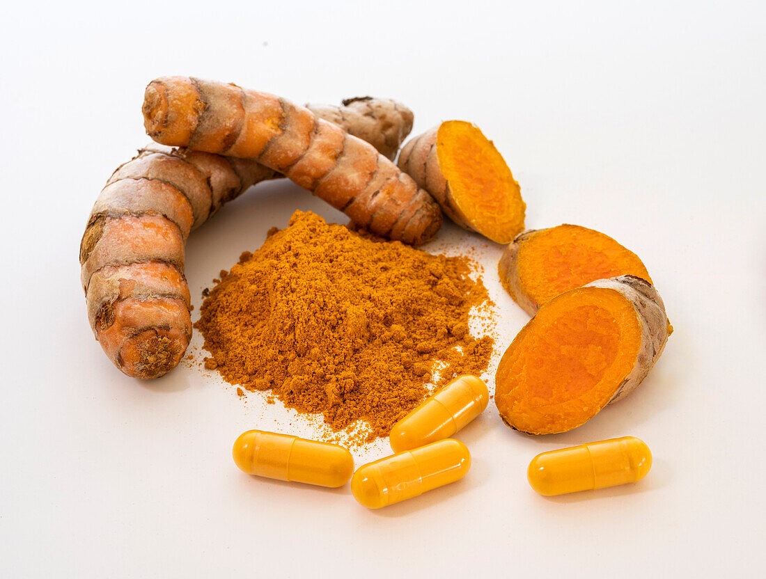 Turmeric powder, root and capsules on white background