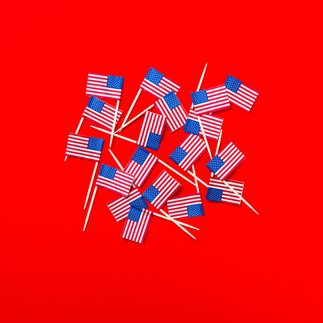 Kleine amerikanische Flagge mit Zahnstochern auf rotem Hintergrund