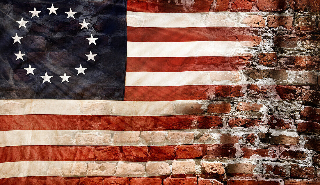 Betsy Ross flag with 13 stars on brick wall