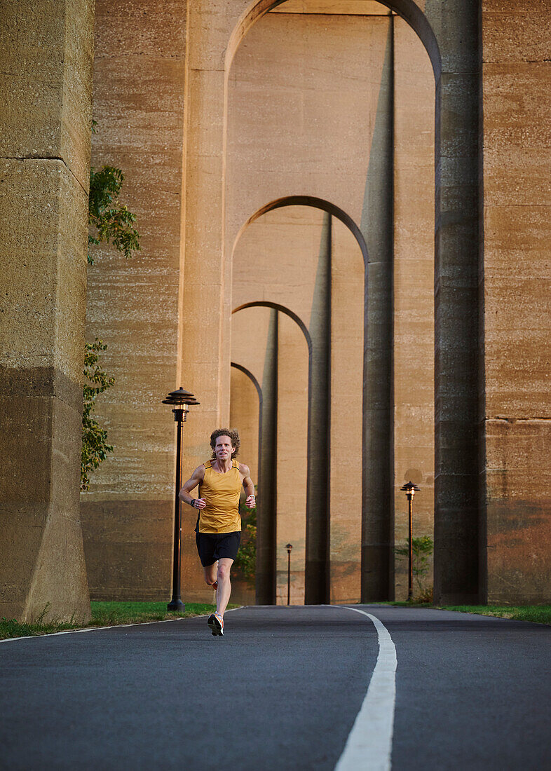 Man jogging under bridge