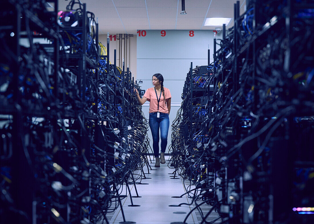 Female technician working in server room