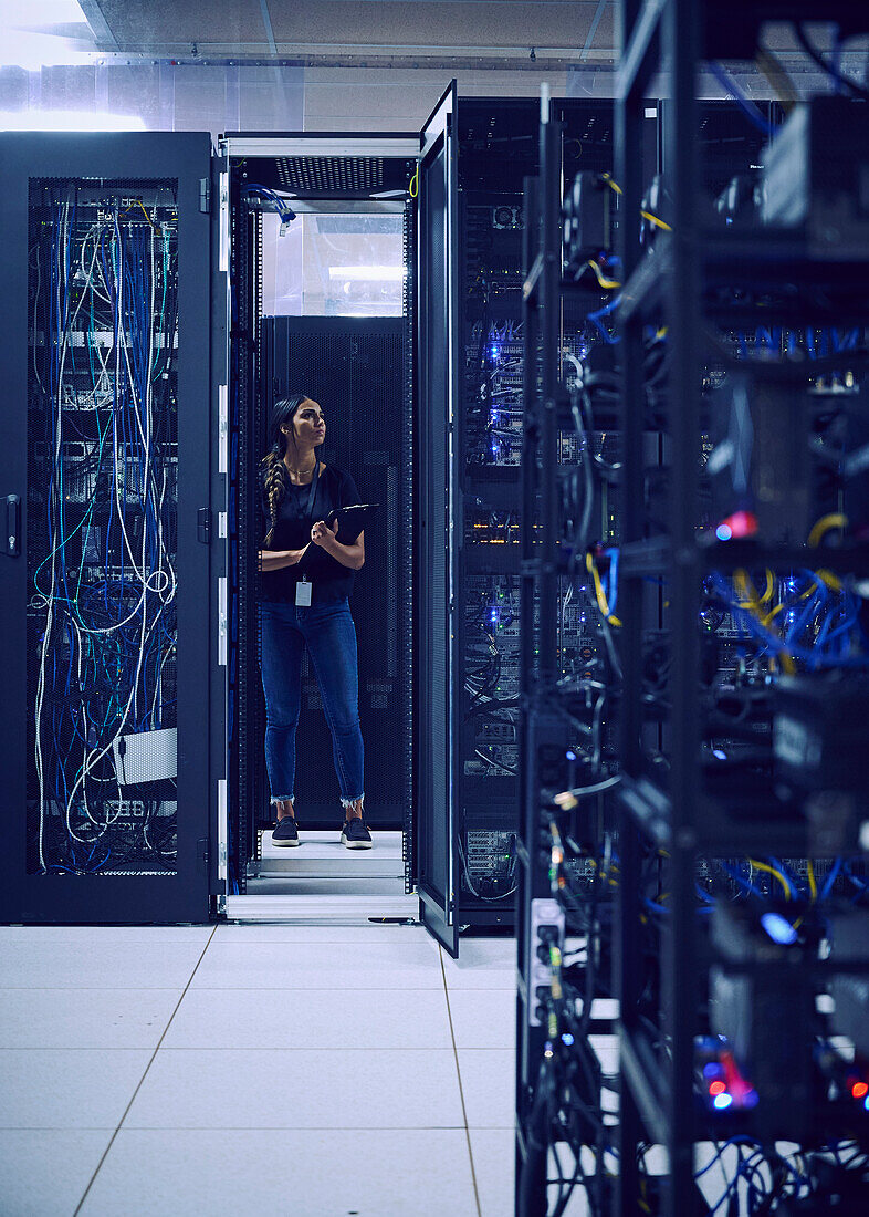 Female technician working in server room