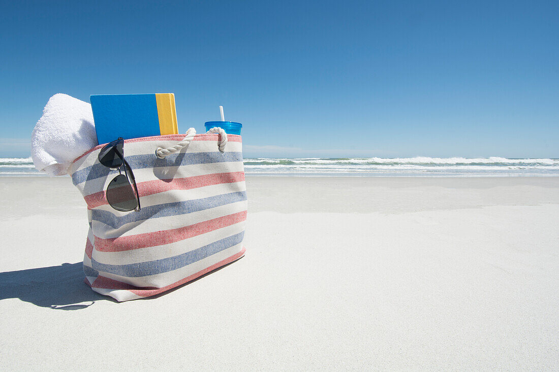 Strandtasche mit Handtuch, Buch und Sonnenbrille am Strand, Topsail Island