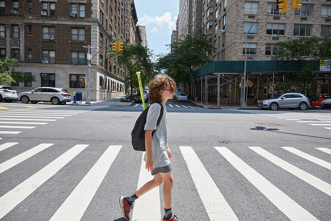 USA, New York, New York City, Junge überquert Straße