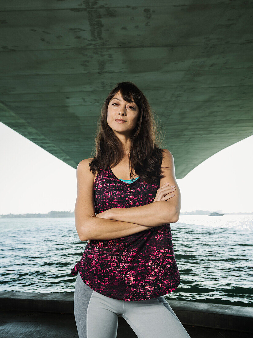Porträt einer Frau in ärmellosem Top unter einer Brücke