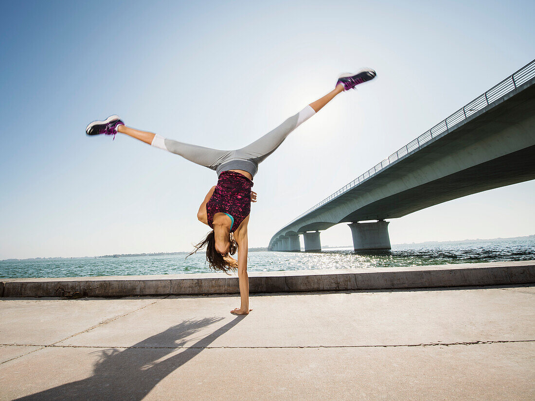 Frau macht Handstand im Freien