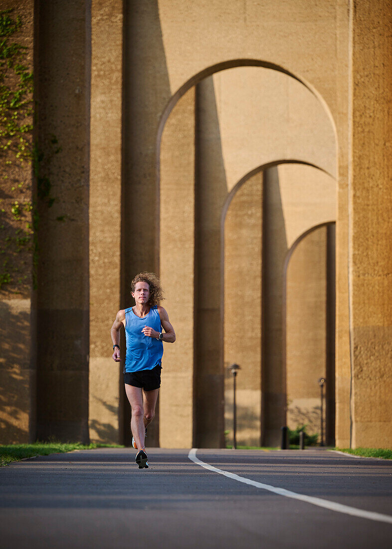 Man jogging under bridge