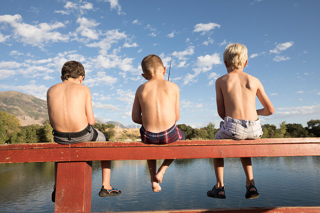Vereinigte Staaten, Utah, Highland, Rückansicht von hemdlosen Jungen (8-9) beim Angeln am See