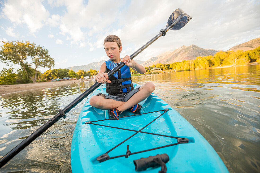 United States, Utah, Highland, Boy (8-9) kayaking on lake