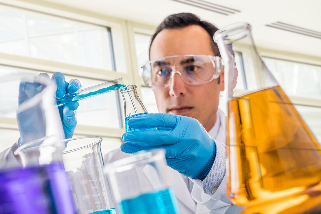 Scientist pouring blue liquid in laboratory