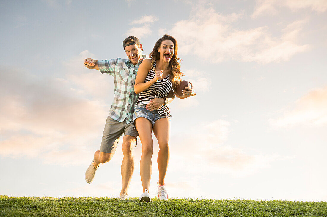 Man and woman playing ball in park 