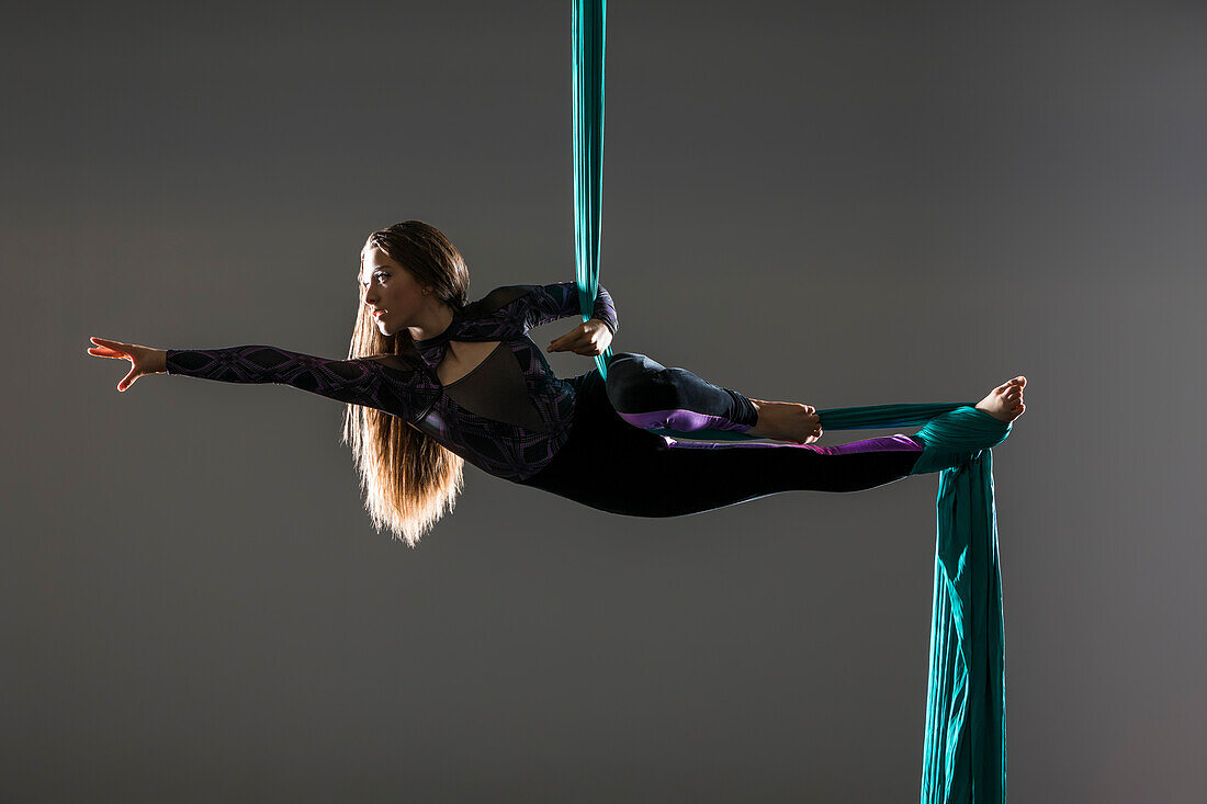 Teenage girl (14-15) practicing aerial silk 