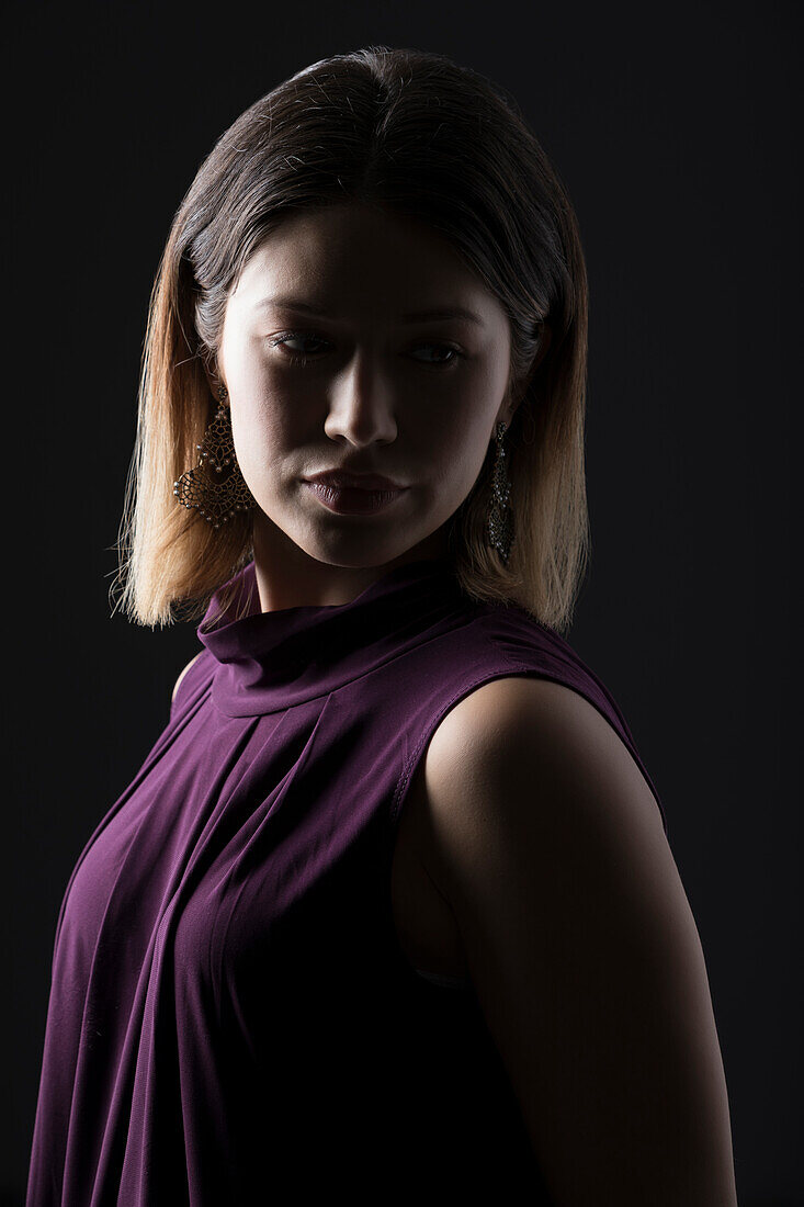 Studio portrait of woman in sleeveless purple top