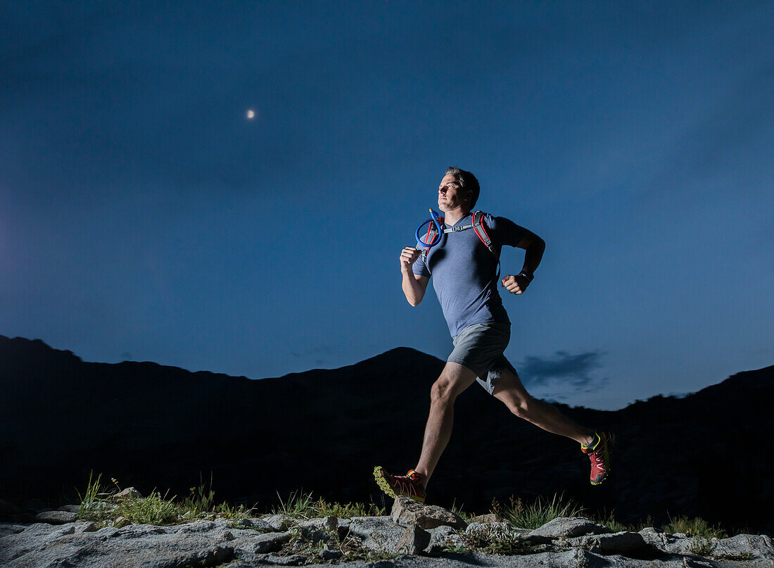Vereinigte Staaten, Utah, Alpine, Mann joggt in den Bergen bei Nacht