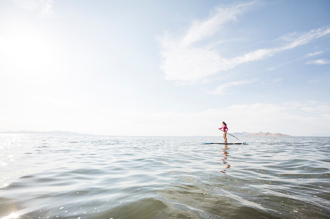 Frau paddelt auf einem See