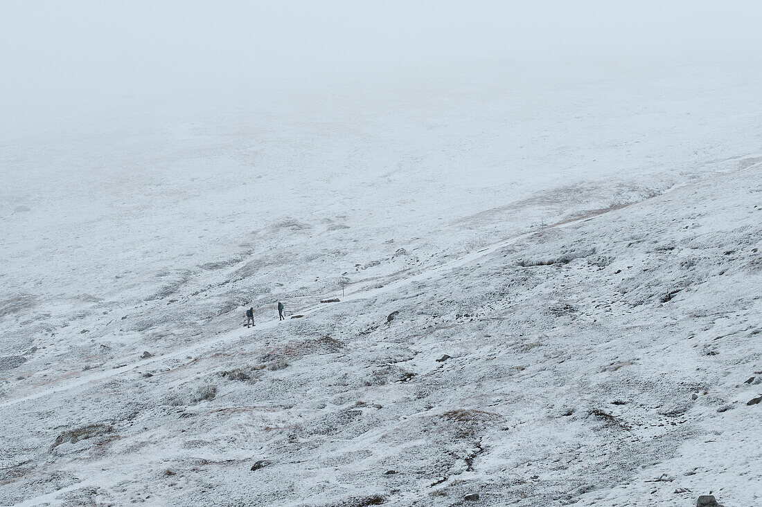 Australien, New South Wales, Verschneite Berglandschaft am Charlotte Pass im Kosciuszko-Nationalpark mit zufälligen Personen auf dem Weg