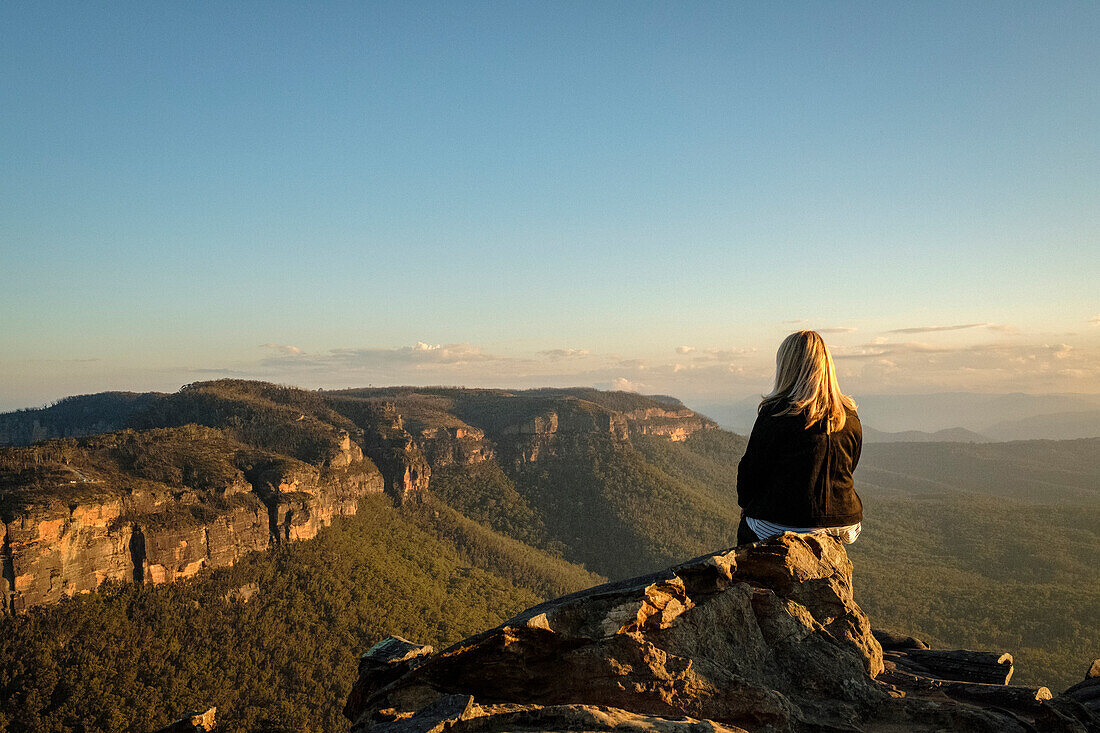 Australien, NSW, Blue Mountains National Park, Rückansicht einer Frau mit Blick auf die Aussicht im Megalong Valley bei Sonnenuntergang