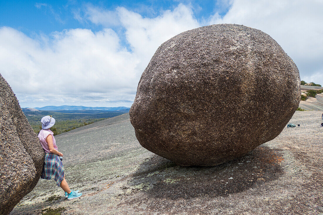 Australien, New South Wales, Bald Rock National Park, Frau steht neben einem großen Felsbrocken
