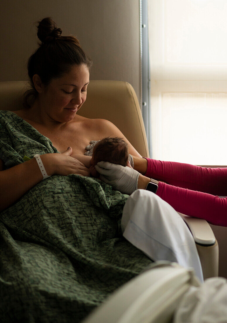 Mother breastfeeding newborn baby girl (0-1 months)