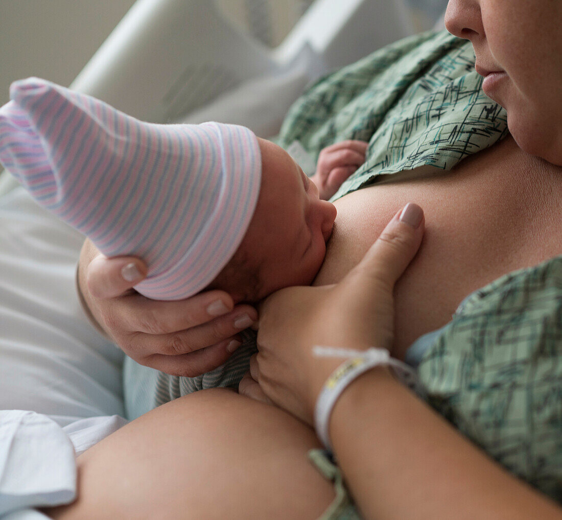 Mutter stillt neugeborenes Mädchen (0-1 Monate)