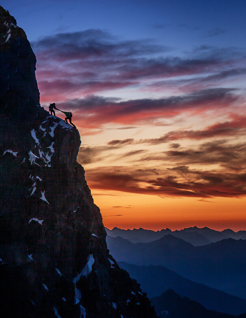 Frankreich, Haute Savoie, Chamonix, Silhouetten von Bergsteigern am felsigen Rand des Mont Blanc bei Sonnenuntergang