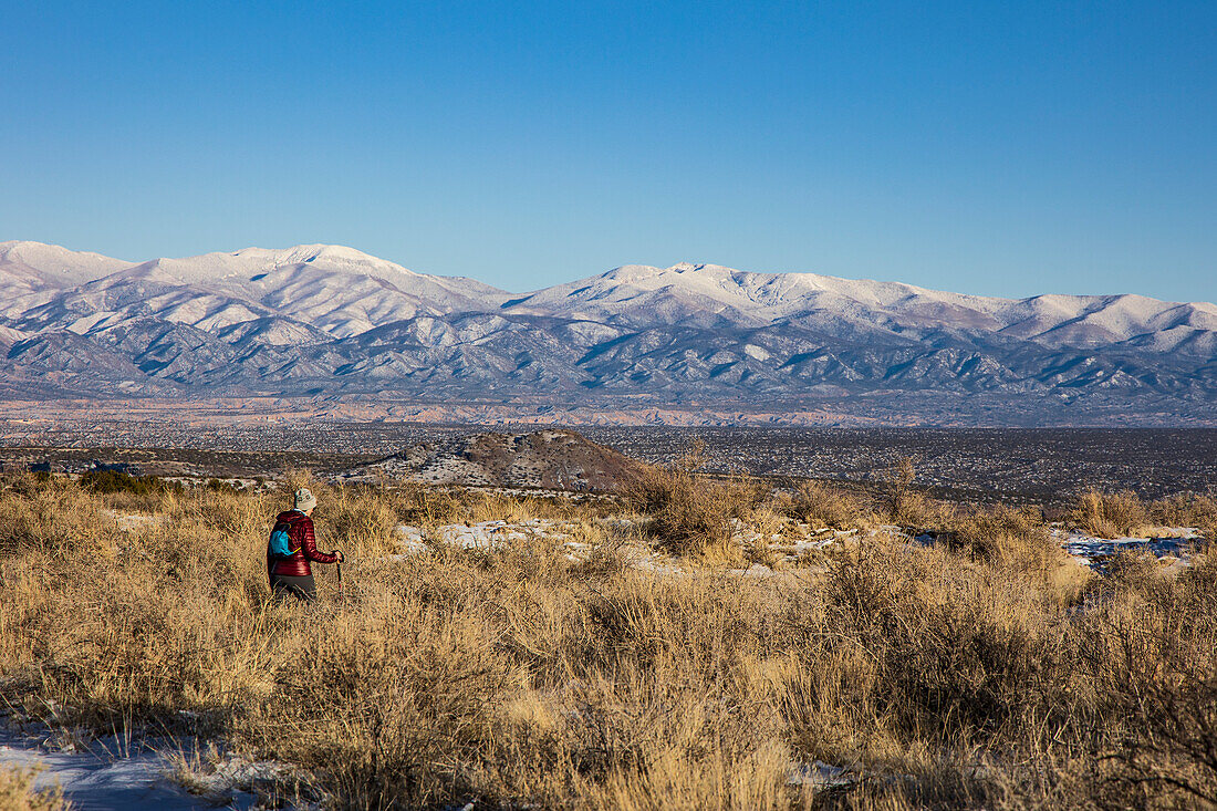 USA, New Mexico, Los Alamos, Bandelier national Monument, Tsankwai, Frau wandert in verschneiter Wüste