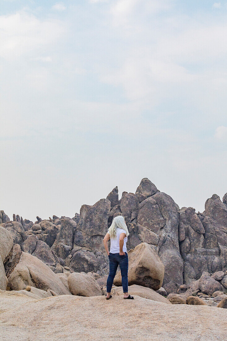 USA, California, Lone Pine, Woman looking at Alabama Hills rock formations in Sierra Nevada Mountains