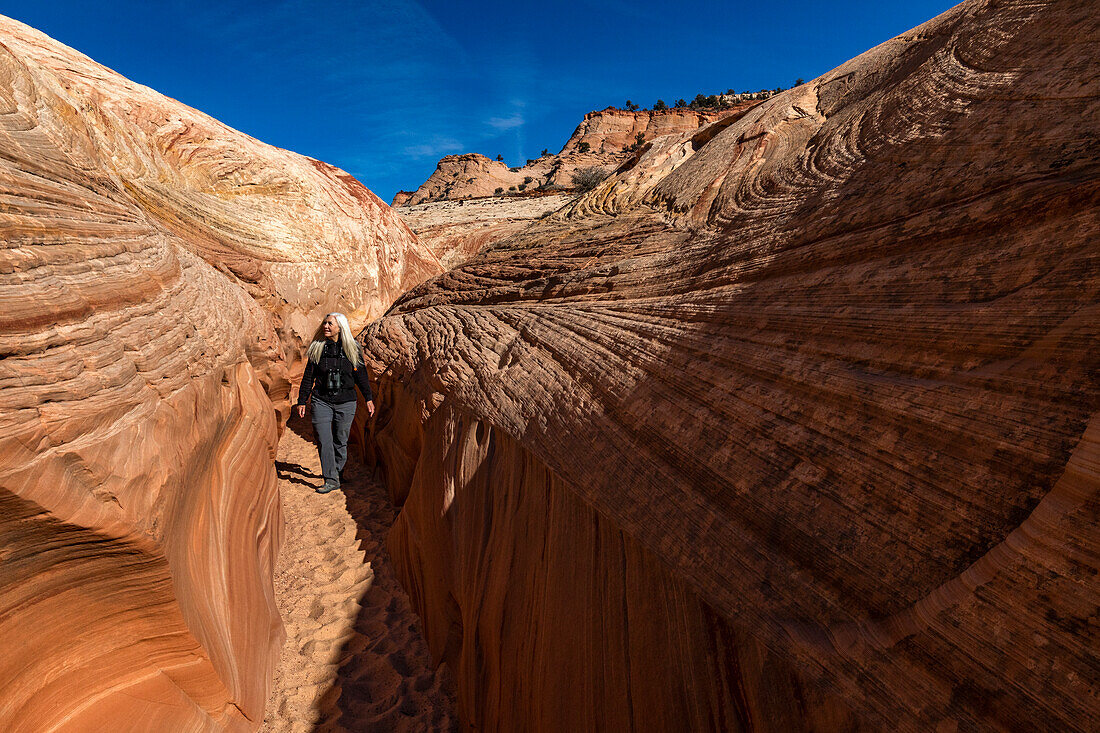 United States, Utah, Escalante, Senior hiker walking in sandstone canyon