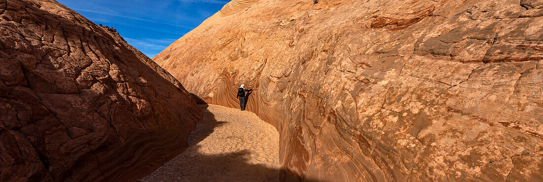 United States, Utah, Escalante, Senior hiker walking in sandstone canyon