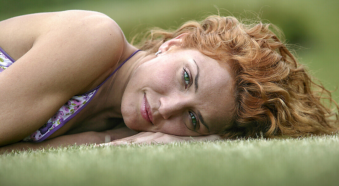 Junge Frau im Gras liegend