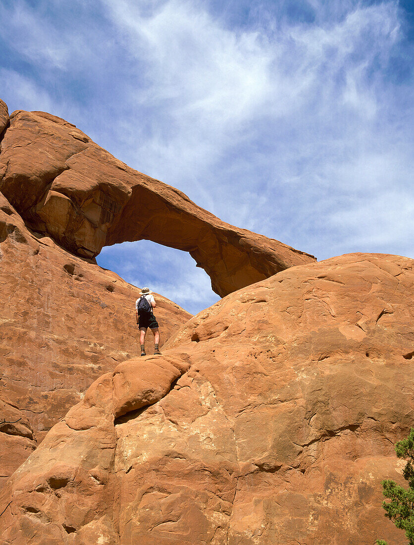 USA, Utah, Arches National Park, Rückansicht eines Mannes mit Blick auf einen Felsbogen