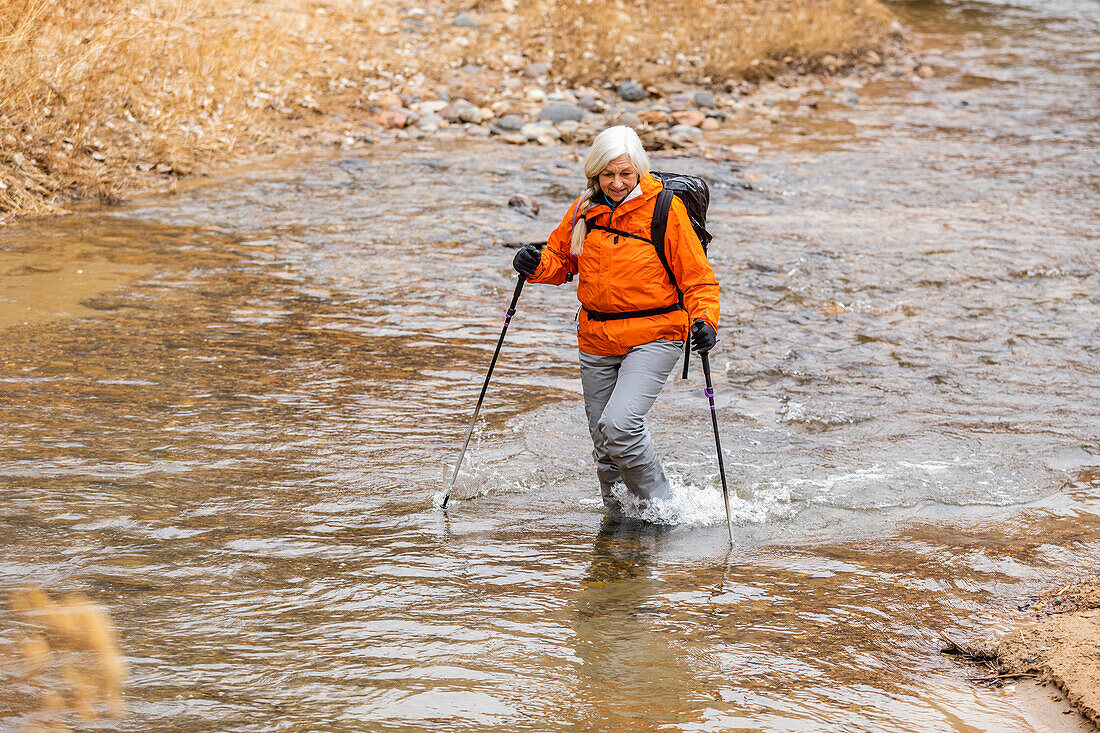 USA, Utah, Escalante, Frau watet durch den Escalante-Fluss im Grand Staircase-Escalante National Monument