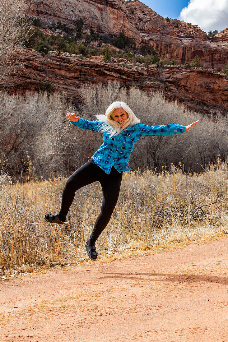 USA, Utah, Escalante, Woman jumping for joy in Grand Staircase-Escalante National Monument