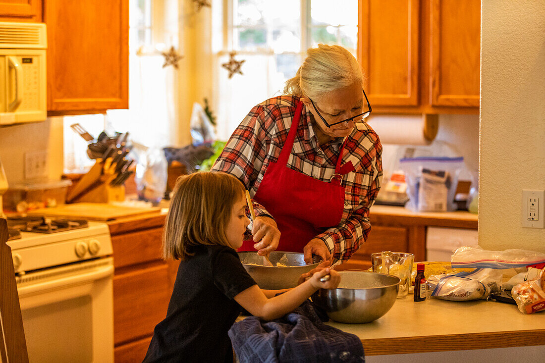 Grandmother and granddaughter (6-7) bake cookies together 