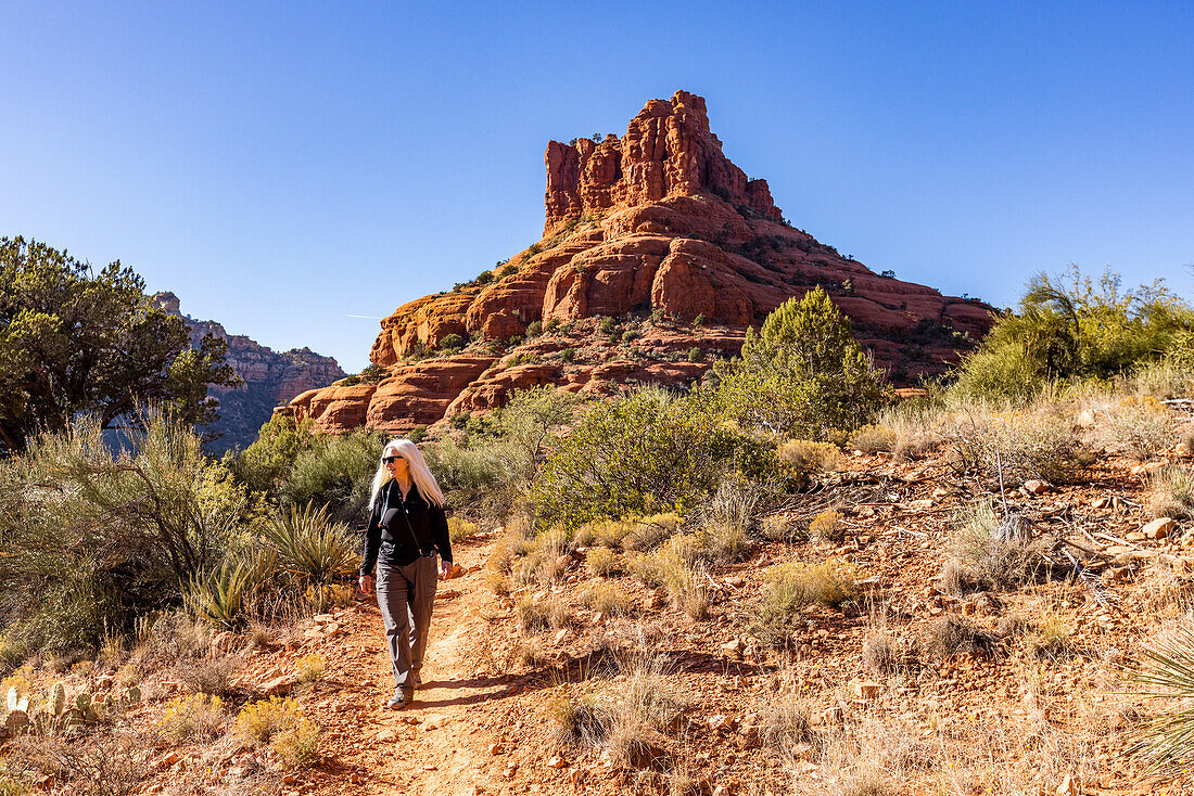 United States, Arizona, Sedona, Senior blonde woman hiking in wilderness