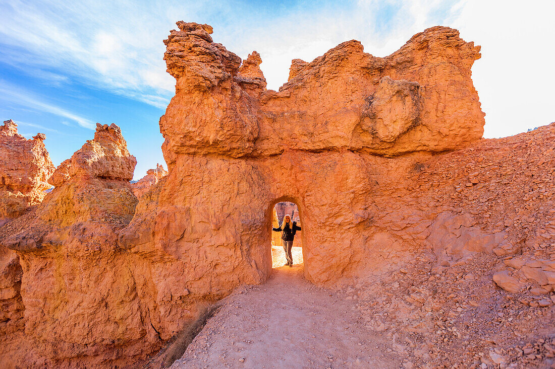 Vereinigte Staaten, Utah, Bryce Canyon National Park, Älterer Wanderer steht in einem Sandsteinbogen