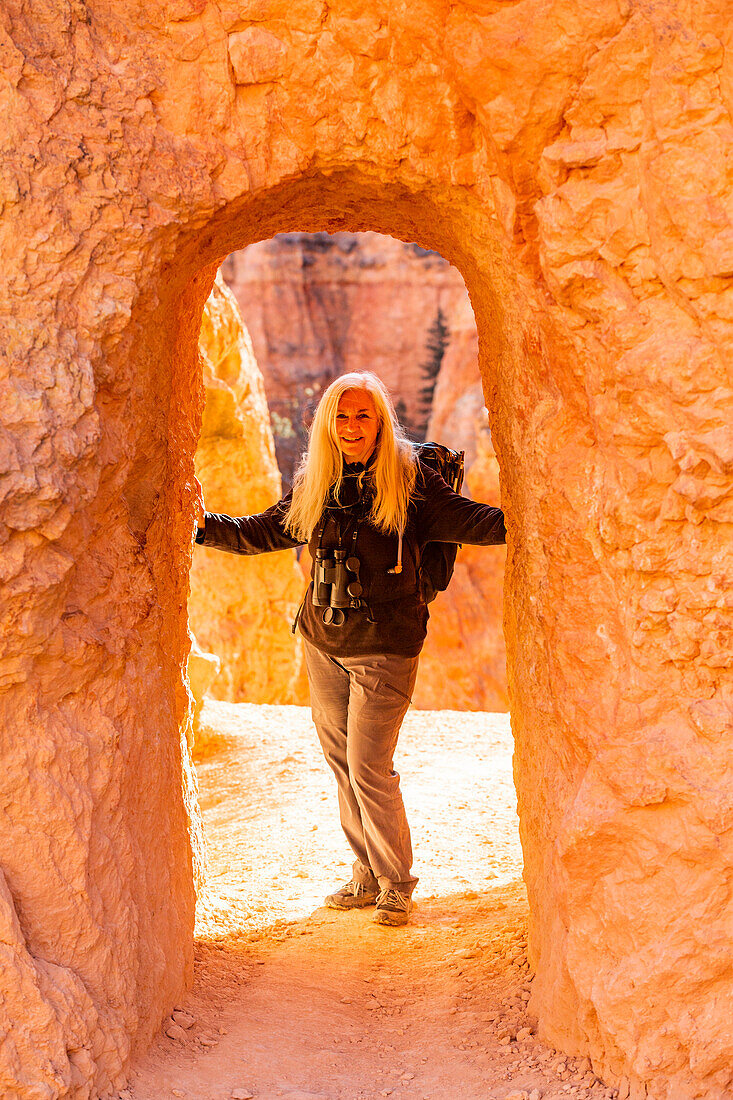 United States, Utah, Bryce Canyon National Park, Senior hiker standing in sandstone archway
