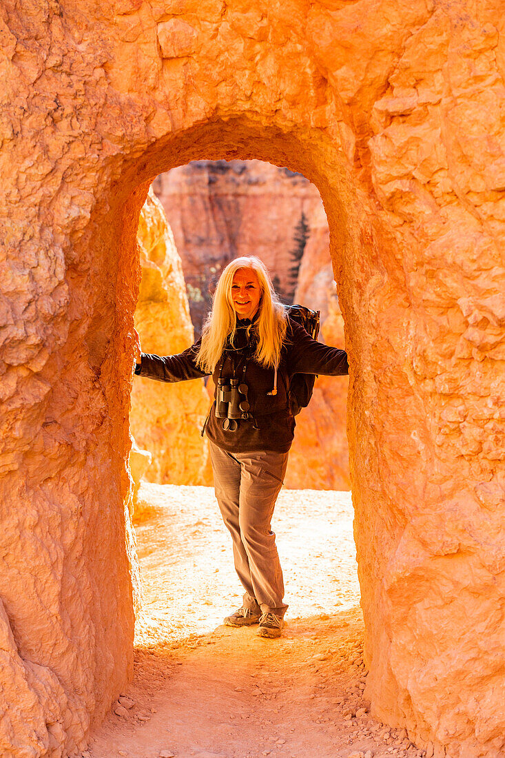 Vereinigte Staaten, Utah, Bryce Canyon National Park, Älterer Wanderer in Sandsteinbogen stehend