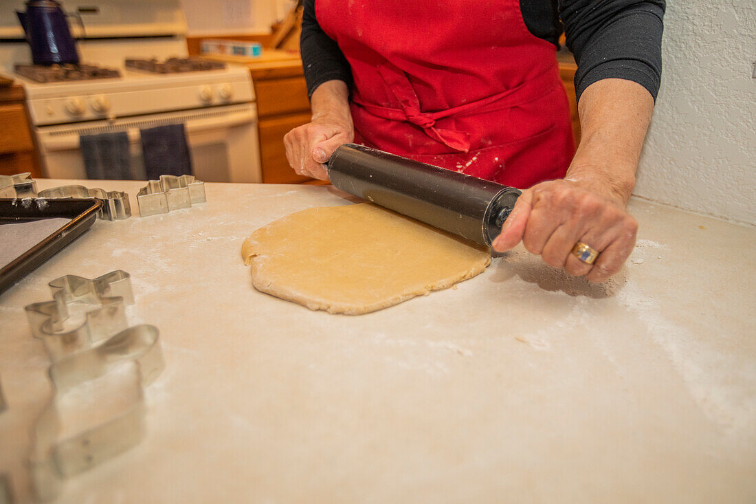 Woman baking Christmas cookies in kitchen