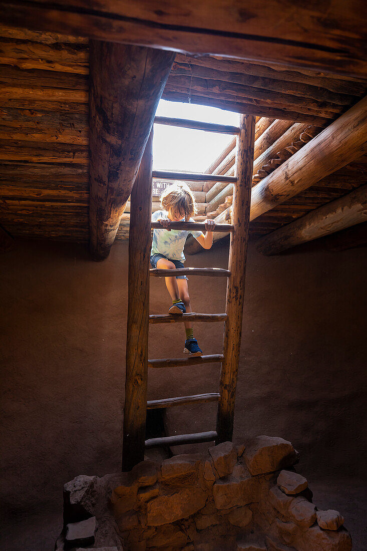 Boy (8-9) exploring Native American kiva in Pecos National Monument