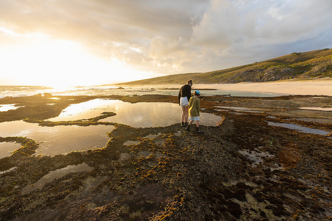 South Africa, Western Cape, Boy (8-9) and girl (16-17) exploring tidal pools in Lekkerwater Nature Reserve