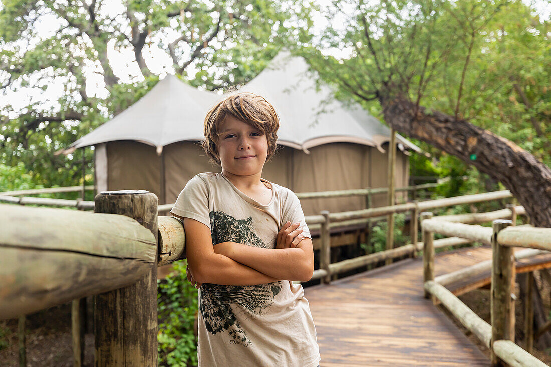 Afrika, Nördliches Namibia, Porträt eines Jungen (8-9) auf einem Holzsteg in der Nambwa River Lodge