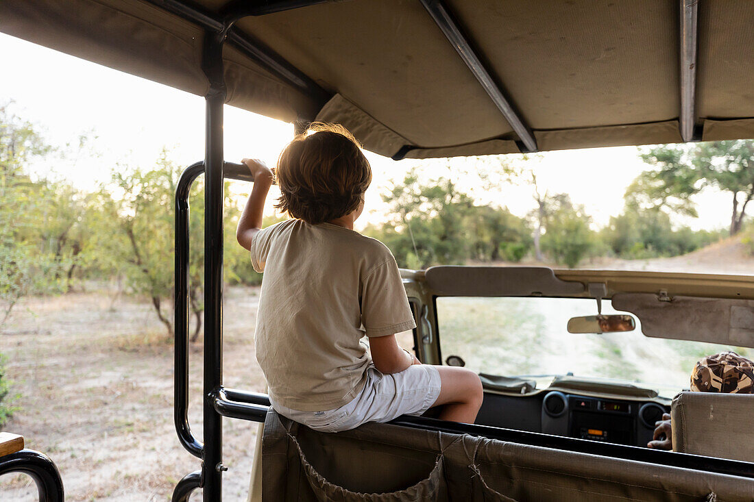 Africa, Namibia, Boy (8-9) in safari vehicle