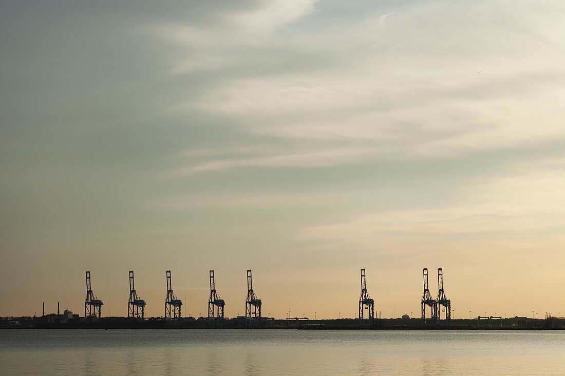 USA, Virginia, Schiffskräne im Hafen bei Sonnenuntergang